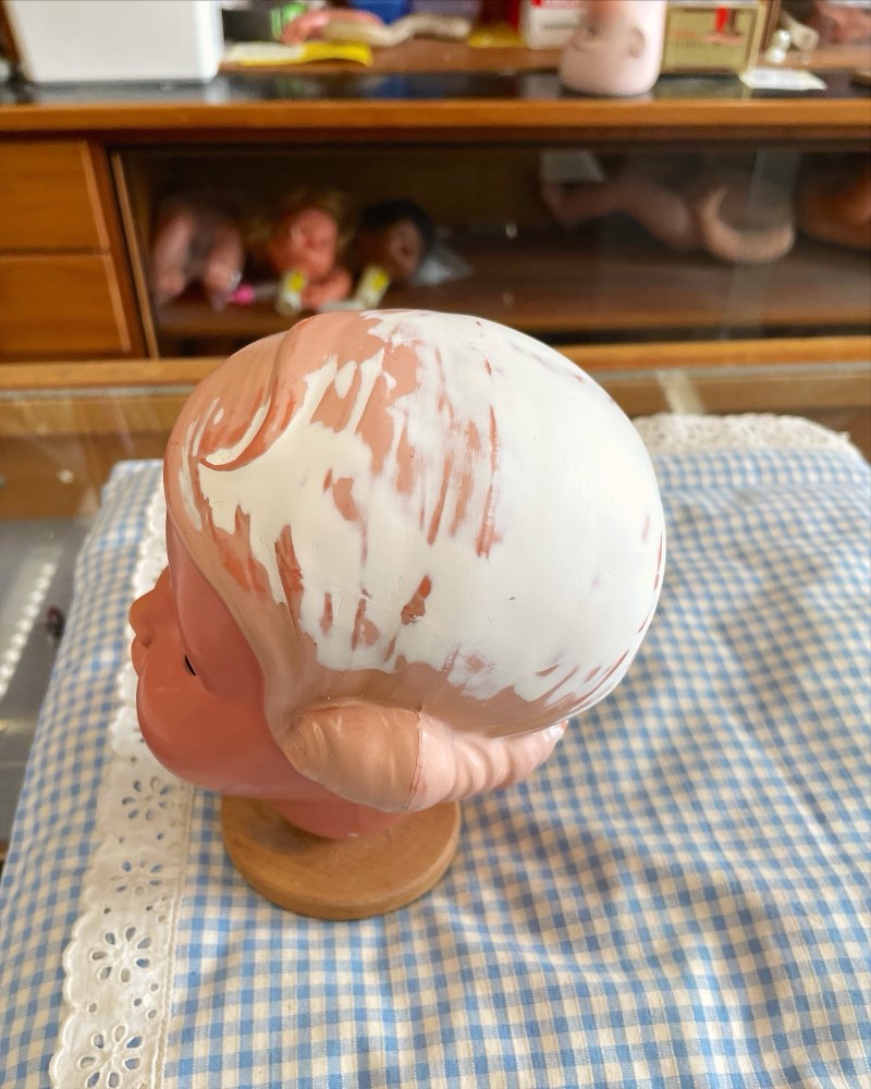Puppenkopf mit abgeplatzter Haarbemalung