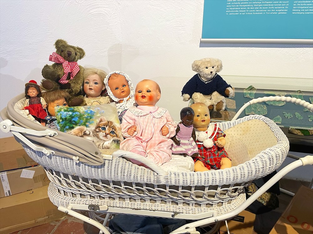 Alter Korbkinderwagen voller Puppen und Teddys am Stand auf dem Flachsmarkt