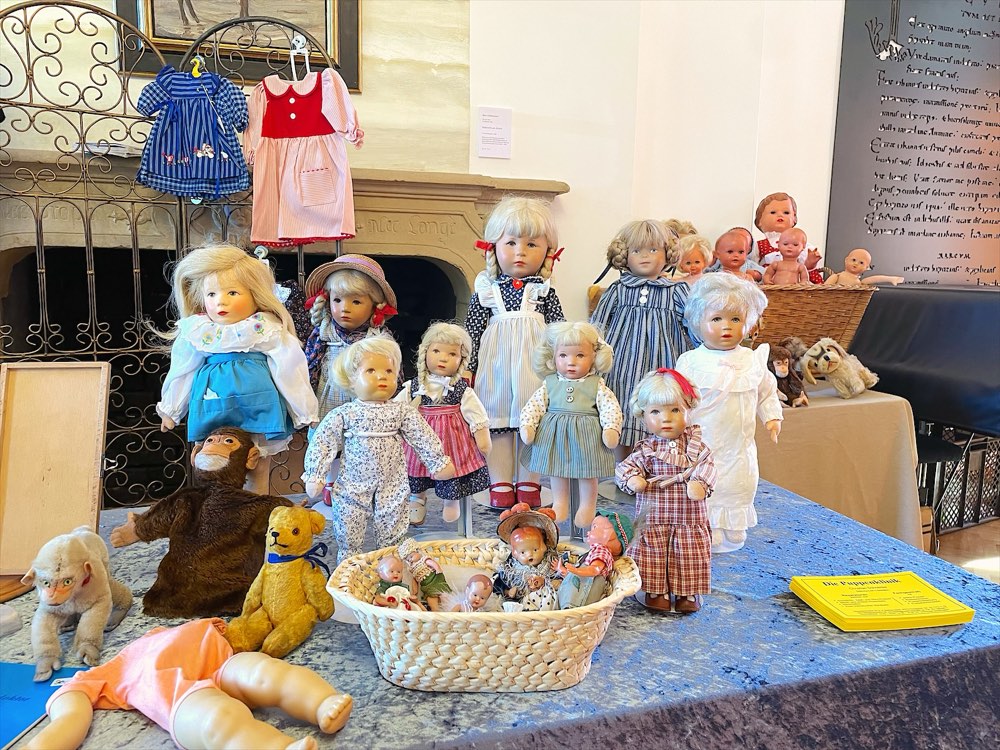 Tisch voller alter Puppen am Stand beim Handwerkstag im Museum Abtei Liesborn